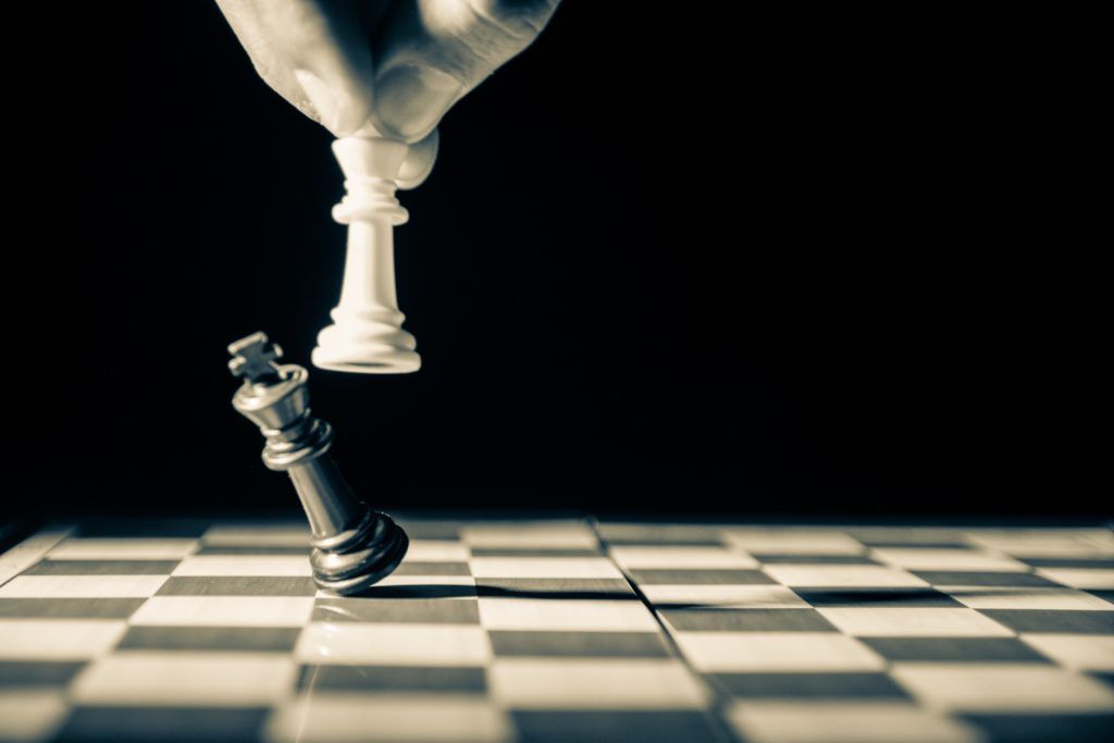Leeres Schachbrett, auf dem eine weiße Figur den schwarzen König schlägt